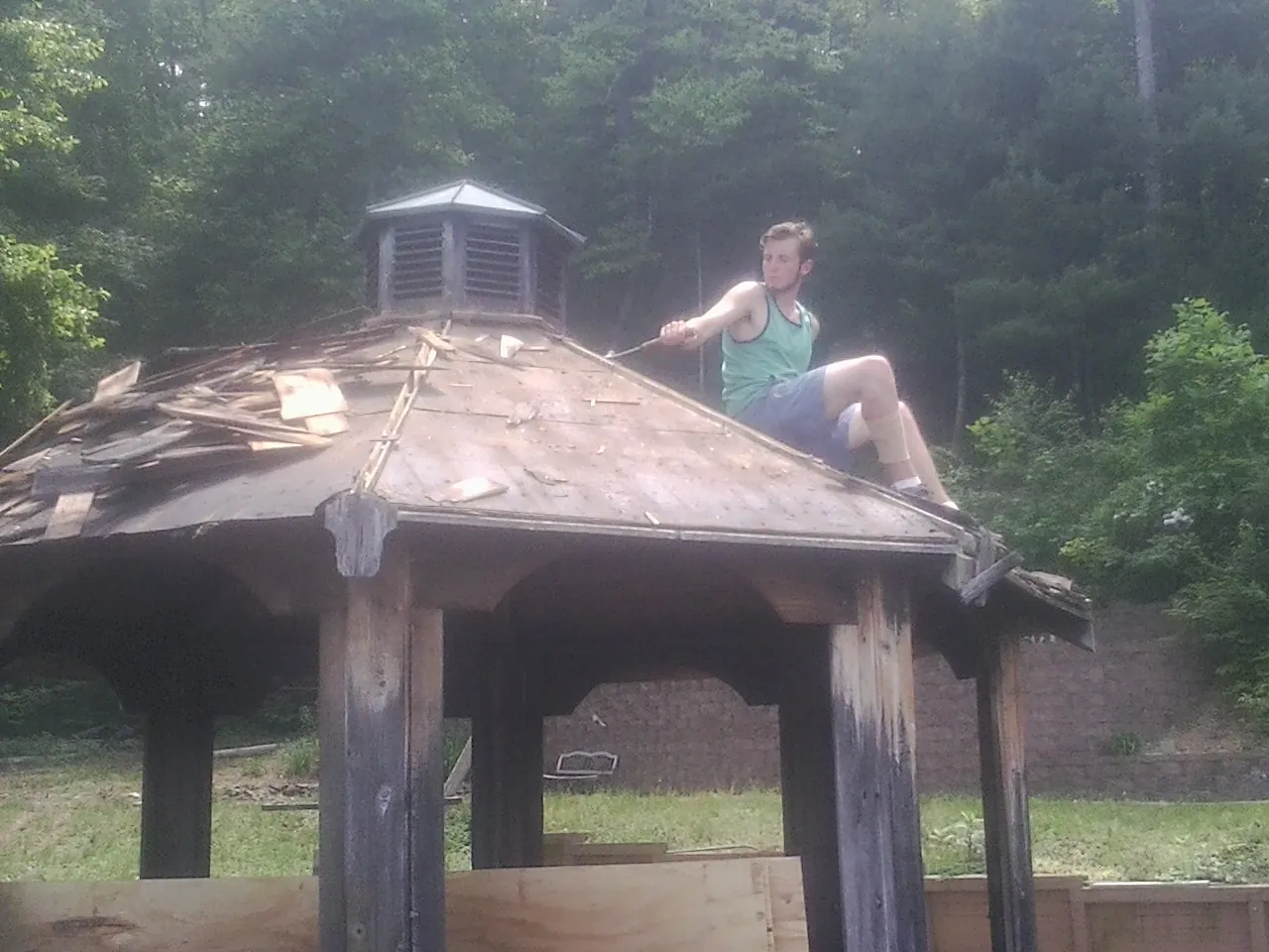 Tearing the old roof off a wooden gazebo before new shakes in Shepherdstown