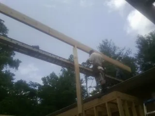 Carpenter setting a ridge beam over a new addition frame — Ice Dam Removal by Roofing Brothers in Shepherdstown