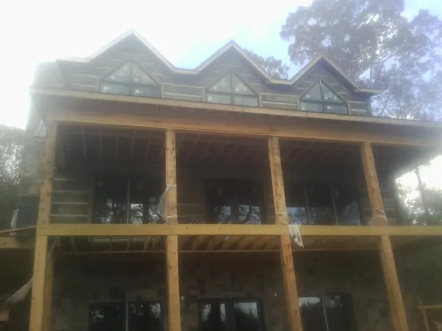 Dormers and porch framing on a large log home under construction — Roof Coating work by our crew in Shepherdstown