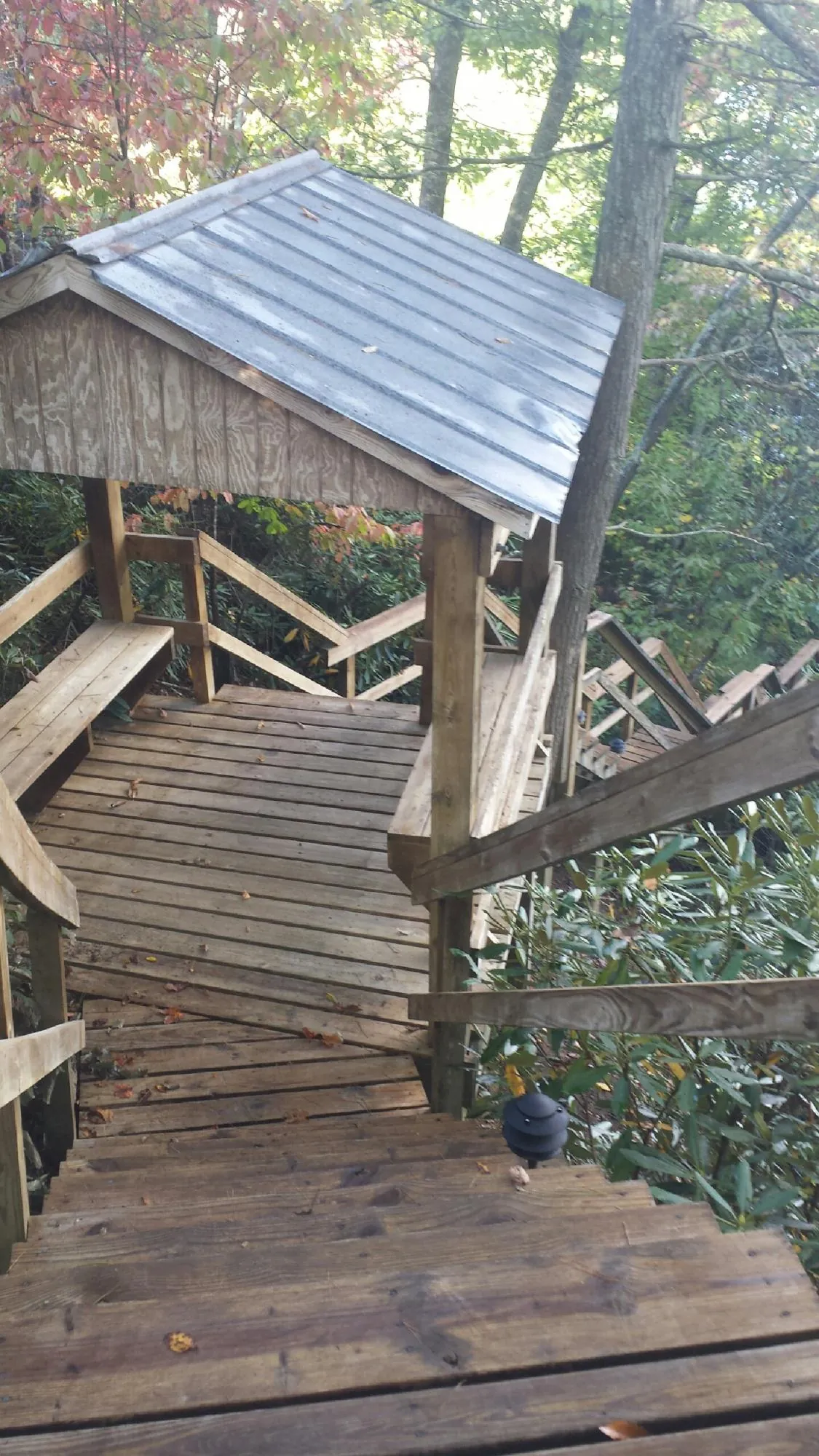 Metal roofed shelter over wooden steps on a wooded walkway — Skylight Repair & Installation work by our crew in Shepherdstown